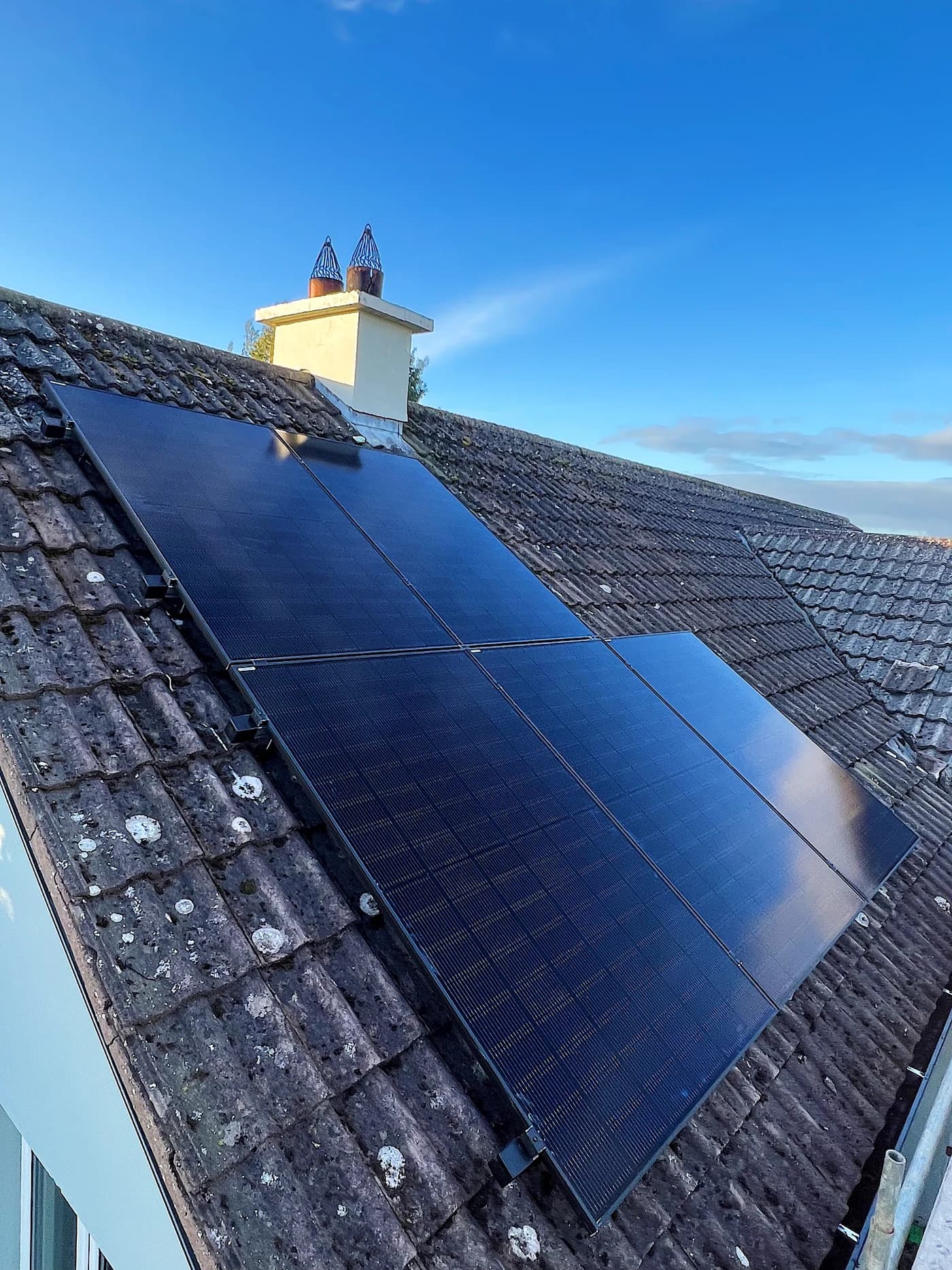 Neatly aligned black solar panels on an Irish slate roof