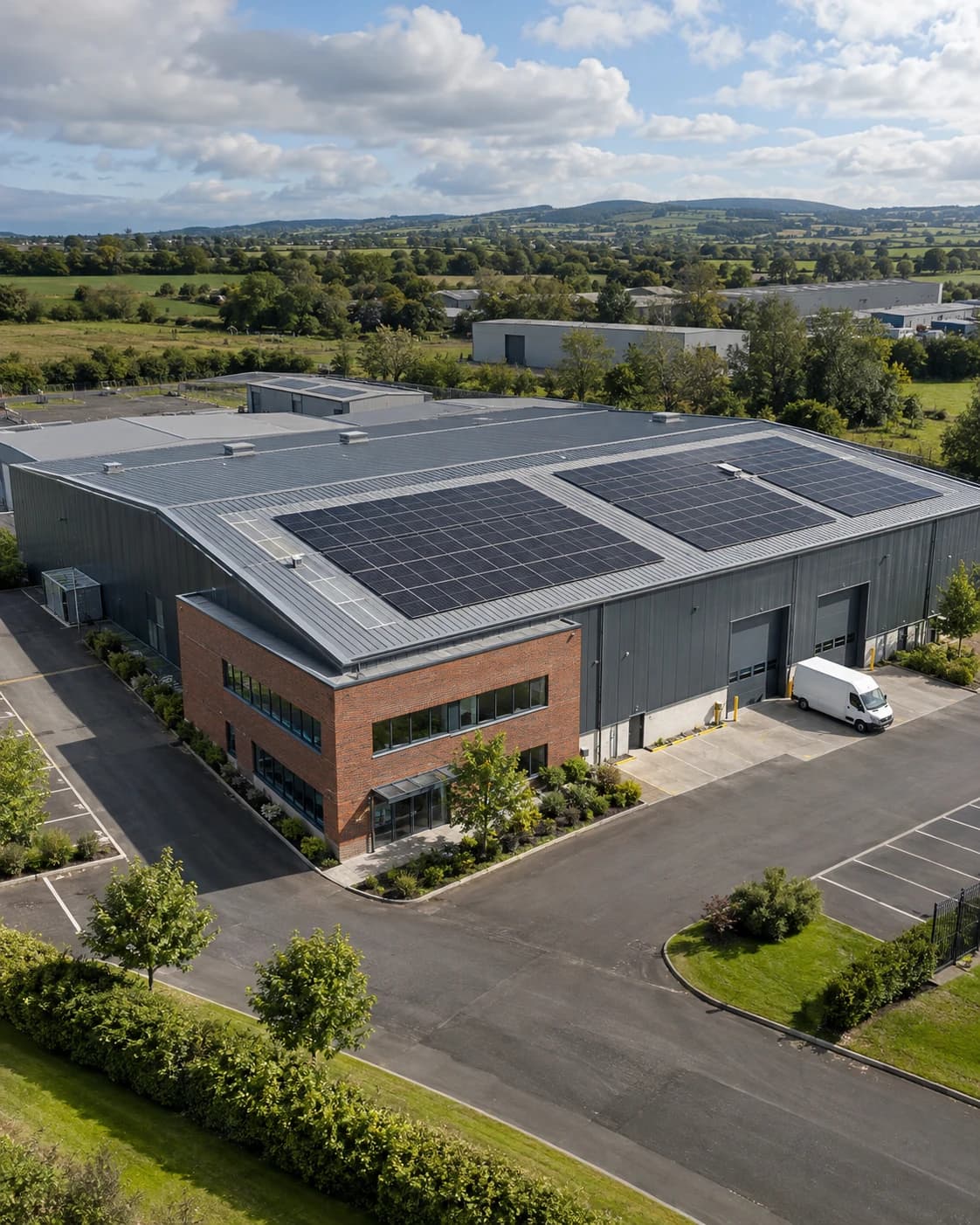 Architectural concept of an Irish commercial premises with rooftop solar, a brick office wing and a clear delivery yard